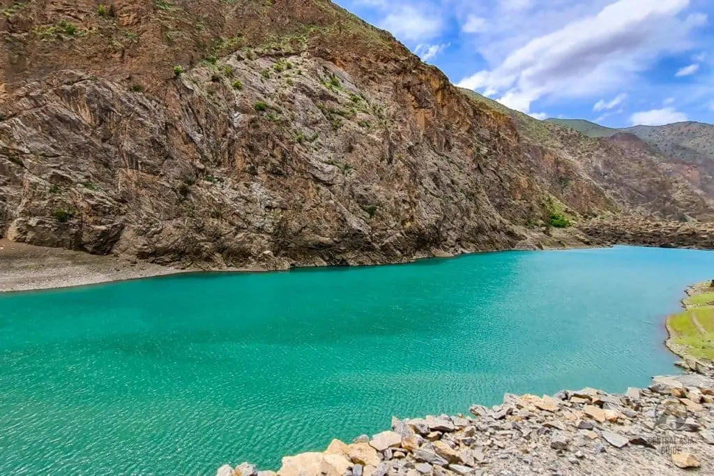 Turquoise Seven Lakes water beneath rocky slopes in the Fann Mountains